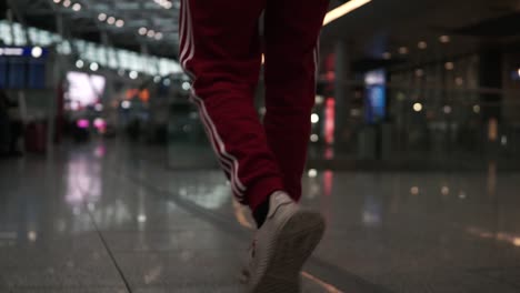 Man-walking-through-airport-terminal,-searching-for-place-to-eat-and-shop