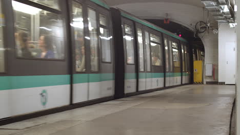 A-full-metro-with-people-in-Paris-leaving-the-station-and-disappearing-into-the-tunnel-with-one-person-waiting-on-the-platform-for-the-next-train