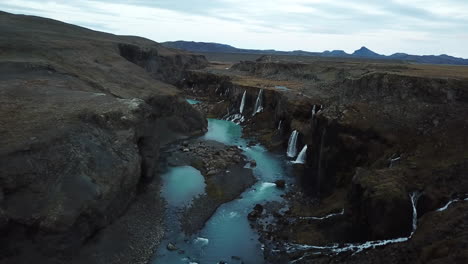 Impresionante-Paisaje-De-Islandia,-Vista-Aérea-De-Cascadas,-Acantilados-Volcánicos-Y-Cañón-Con-Agua-Azul-Fría-Del-Río-Glacial