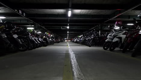 Wide-angle-view-of-traveling-down-rows-of-many-parked-motorcycles-in-a-large-garage