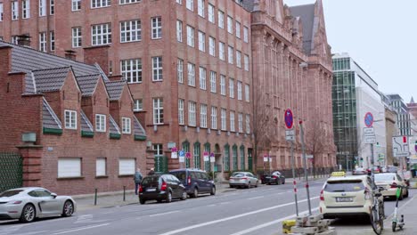 Schönes-Altes-Haus-In-Der-Düsseldorfer-Altstadt,-Braunes-Gebäude-Mit-Vorbeifahrendem-Auto,-Das-In-Zeitlupe-Schwenkt