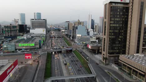 Imágenes-Aéreas-Editoriales-De-4k-De-Los-Edificios-Entel,-Plaza-Vea,-Tottus-Y-Petroperú-En-La-Concurrida-Zona-Del-Carnaval-Y-Moreryra-Y-La-Intersección-Vía-Expressa-En-La-Ciudad-Capital-De-Lima,-Perú