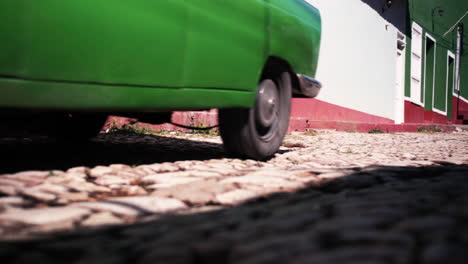 Classic-vintage-car-painted-bright-green-driving-along-the-cobblestones-of-Trinidad-in-Cuba