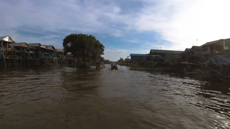 Landscape-POV-of-boats-sail-over-real-flooded-village,-Kompong-Khleang-in-Siem-Reap