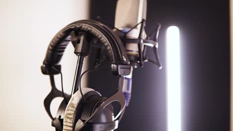 A-Headphone-And-Microphone-Set-In-The-Studio---close-up-swinging-shot