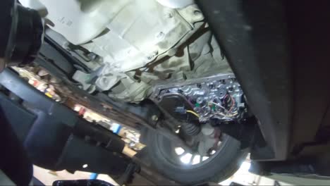 An-Automotive-Service-Technician-Re-installs-a-Transmission-Pan-Onto-A-Car-During-Routine-Maintenance-Shot-From-A-First-Person-Perspective