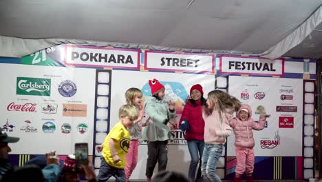 Children-enjoying-and-having-fun-dancing-and-jumping-in-the-stage-during-the-21st-street-festival-at-Pokhara,-Nepal