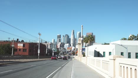 La:-Horizonte-Del-Centro-Desde-El-Puente-De-La-Calle-1-Con-Tráfico-Y-Una-Línea-De-Tren---Los-Angeles,-California,-Estados-Unidos