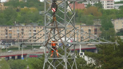 Kletterelektriker-Auf-Einem-Hochspannungsmast-In-Der-Stadt