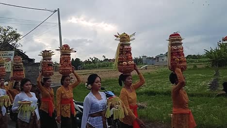 Ceremonia-Balinesa-Mujeres-Caminando-Ofrendas-Florales-En-La-Cabeza-Frutas-Coloridas-Hojas-De-Coco-Y-Ropa-Tradicional