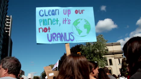 Demonstrant-Hält-Schild-„Räumt-Unseren-Planeten-Auf,-Es-Ist-Nicht-Uranus“-Während-Der-Klimakundgebung
