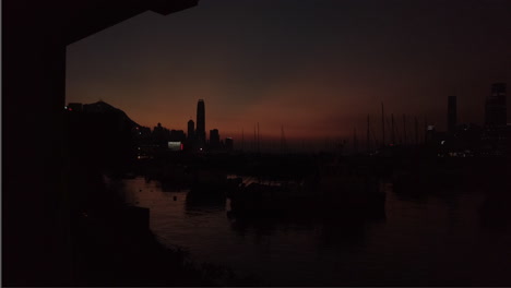 Tiro-Amplio-Atardecer-Lapso-De-Tiempo-Barcos-Anclados-En-El-Agua-Horizonte-De-Hong-Kong