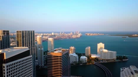 Vista-Aérea-De-Edificios-De-Gran-Altura,-Hacia-Brickell-Key-Y-El-Mar,-Durante-El-Amanecer,-En-Miami,-Florida,-EE.UU.---Aumento,-Disparo-De-Drone