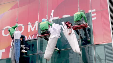 El-Equipo-Está-Colocando-Pegatinas-Publicitarias-En-El-Cristal-De-Un-Edificio-Alto-En-Las-Afueras-De-Bangkok,-Tailandia