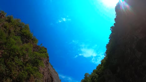 Beautiful-gorge-with-rocky-sharp-slopes-of-mountains-on-valley-with-turquoise-water-of-river-where-young-people-camping