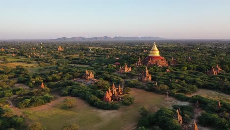 Aerial-push-in-to-Dhammayazika-Pagoda-temple-at-sunrise,-Pwasaw,-Myanmar