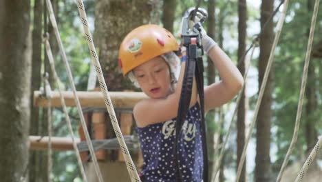 Little-girl-with-red-hair-has-fun-in-adventure-park-in-the-Italian-Alps-close-up,-slow-motion