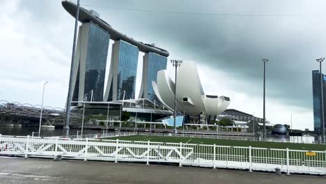 Nubes-De-Tormenta-Sobre-El-Museo-De-Ciencias-Del-Arte-Y-El-Lujoso-Puerto-Deportivo-Bay-Sands-Con-Pocas-Personas-En-Bicicleta-En-Singapur