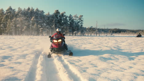 Hombre-En-Una-Moto-De-Nieve-Girando-Rápidamente-En-Un-Lago-Nevado-Un-Soleado-Día-De-Invierno