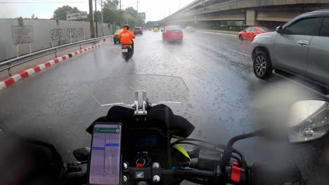 Riding-a-motorcycle-in-traffic-of-Bangkok-during-a-heavy-rain