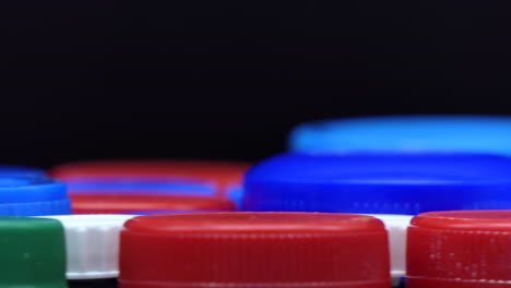 Colourful-plastic-caps-that-spin,-very-shallow-depth-of-field,-close-up-front-view