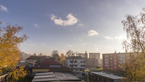 Time-lapse-video-capturing-the-residential-part-of-the-city-during-the-low-fog-sunshine-above-the-ground-with-traffic-on-the-main-road-and-moving-clouds