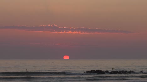 Entspannender-Sonnenaufgang-Am-Strand-Mit-Sonnenbeschienenen-Wolken,-Mittelmeer