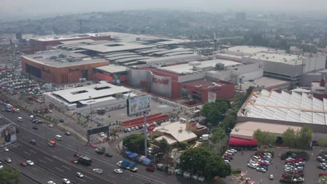 Drone-Aerial-View-of-Everyday-Busy-Traffic-in-Mexico-City-Metropolitan-Area,-Shopping-and-Department-Store-Buildings