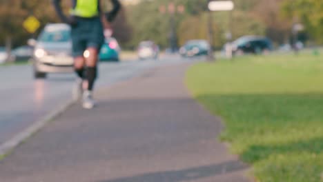 Man-jogging-next-to-road-on-an-Autumn-day-with-traffic-on-road