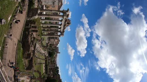 Toma-Vertical-Del-Foro-Romano,-Roma,-Italia,-Cámara-Panorámica-De-Izquierda-A-Derecha-En-Un-Hermoso-Día-De-Primavera-Con-Cielo-Azul-Y-Nubes-Blancas.