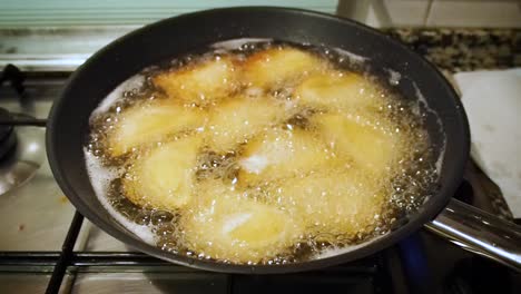 View-footage-of-Rissoles-fried-into-a-pan-full-of-hot-oil-in-her-kitchen