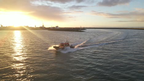 Magical-sunrise-in-Holland-with-boat-leaving-shore-at-Harlingen,-aerial