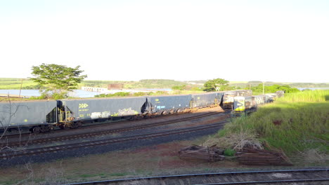 Vista-De-Gran-Angular-Del-Antiguo-Tren-De-Transporte-Que-Transporta-Recursos-En-Un-Ferrocarril-De-Grava-En-Un-Día-Soleado,-La-Señora-Compañía-Ferroviaria-En-El-Puerto-Intermodal