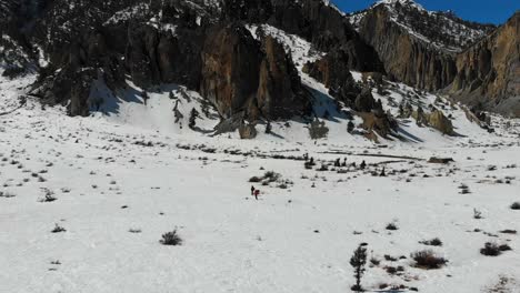 Two-travelers-trekkers-walking-hiking-through-a-snow-field