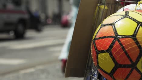 Ein-Bunter-Fußball-Im-Vordergrund-Und-Der-Verkehr-Im-Hintergrund-In-Feira-De-Santana,-Bahia,-Brasilien