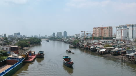 Drone-Tracking-shot-of-freighter-coming-down-the-canal-separating-of-Ho-Chi-Minh-City-in-Vietnam