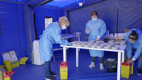 Medium-shot-of-three-medical-assistants-managing-various-doses-of-the-Pfizer-BioNTech-vaccine-in-a-drive-thru-vaccination-center-in-Romania