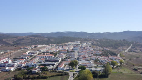 Aerial-drone-flight-towards-the-hills-with-view-of-a-few-villas-in-Aljezur,-Algarve,-Portugal