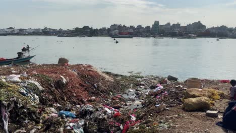 poor-people-scavenging-in-trash-piles-in-Buriganga-river,-Sadarghat-port-region,-old-Dhaka