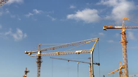 Vier-Topkit-Turmdrehkräne-Rotieren-In-Verschiedene-Richtungen-Auf-Einer-Baustelle-In-4K