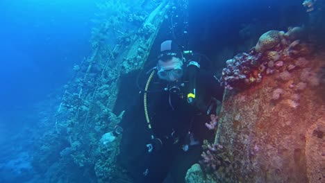 Diver-showing-sign-inside-a-ship-wreck