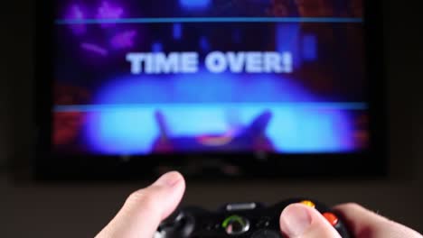 TIME-OVER-POV---point-of-view-of-hands-with-video-game-controller-playing-a-racing-game-and-the-words-TIME-OVER-at-the-end-when-the-race-concludes