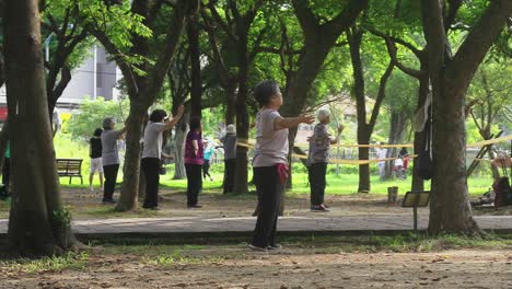 SLOW-MOTION:-Group-of-ladies-exercising-in-Daan-Park-in-Taipei-City,-Taiwan