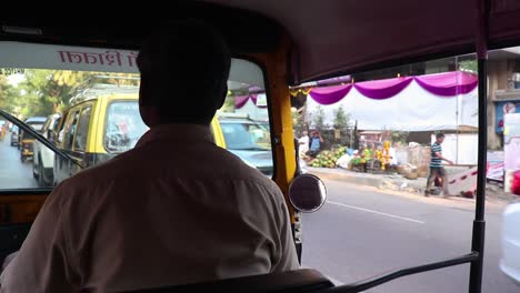 Tiro-Al-Hombro-Del-Conductor-Del-Rikshaw-Automático-Conduciendo-Por-Una-Concurrida-Carretera-India