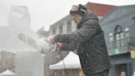 Slomo-rack-focus-of-ice-sculptor-cutting-ice-block-with-chainsaw