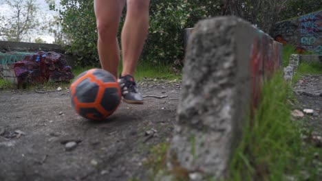 Closeup-of-girl-dribbling-soccer-ball-around-rocks,-controlling-the-ball,-slow-motion-tracking