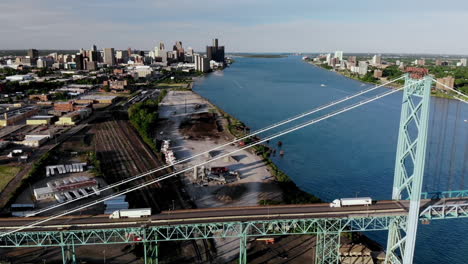 Drone-footage-passing-over-the-Ambassador-Bridge-and-approaching-downtown-Detroit-at-sunset