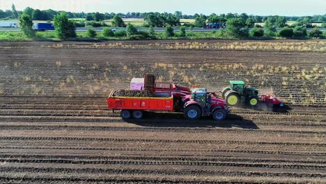An-aerial-side-view-of-a-potato-harvester-working-the-field-on-a-beautiful-sunny-day