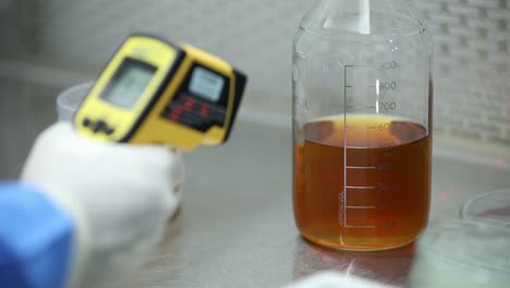 Doctor-checks-temperature-of-a-bottle-with-chemicals