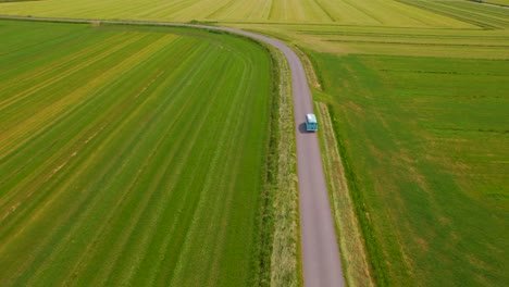 Vista-Aérea-Inclinada-Hacia-Abajo-De-La-Camioneta-VW-Conduciendo-Por-El-Campo